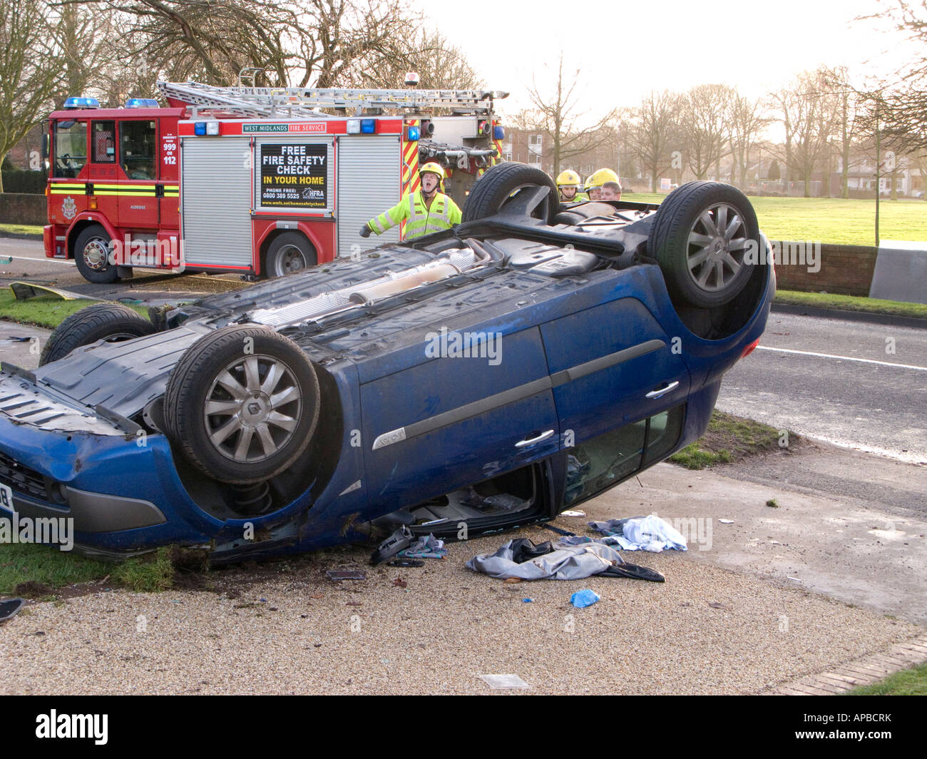 Voiture renversée et le feu moteur au lieu d'un accident de la route , West Midlands , Royaume-Uni Banque D'Images