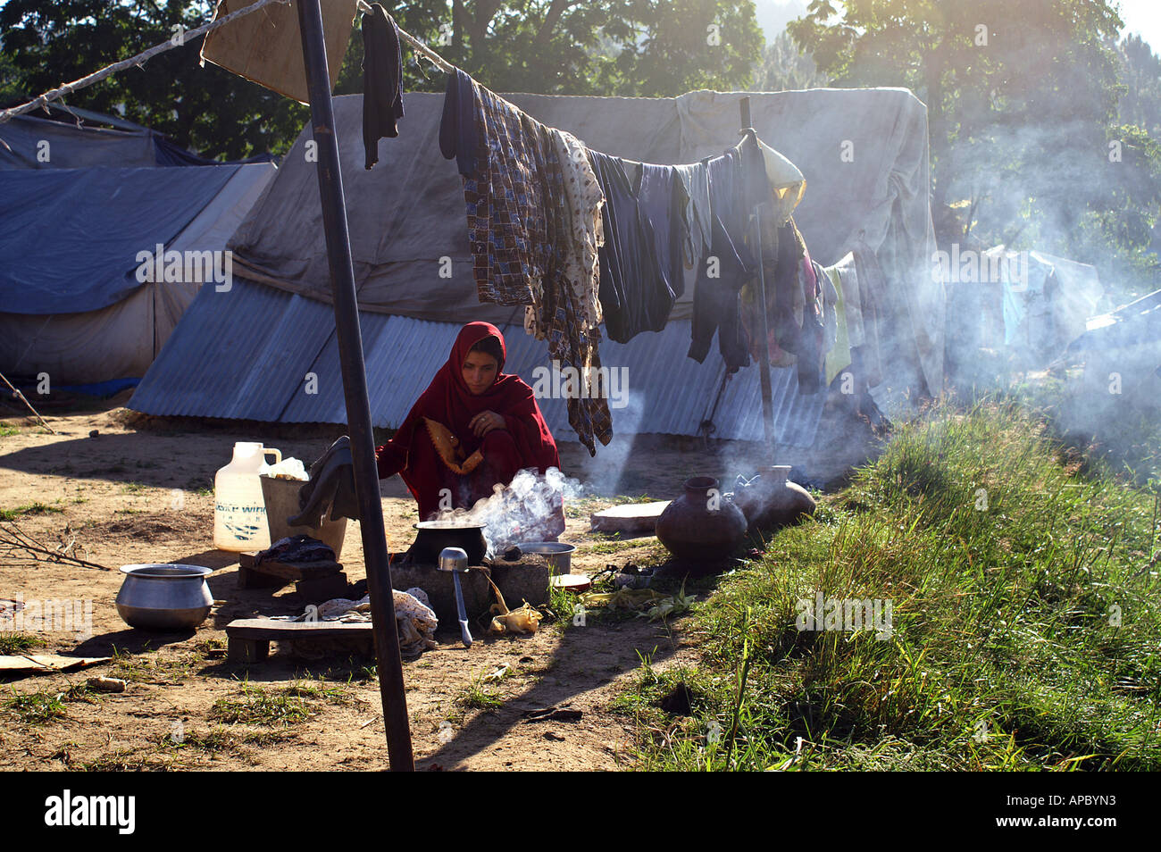 La cuisson à femme ouvrir le feu dans le camp de réfugiés de Jabba, Balakot, NWFP, Pakistan. Le camp est occupé par les victimes de l'Octobre 2005 Banque D'Images