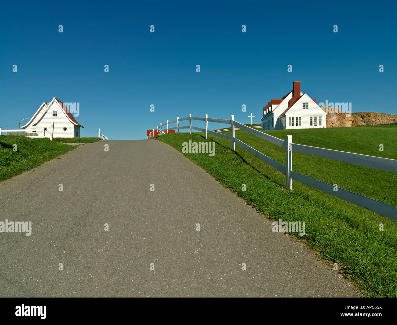 Canada Québec Gaspésie percé route bordée de clôture blanche et maisons en bois blanc dans la ville de Percé Banque D'Images