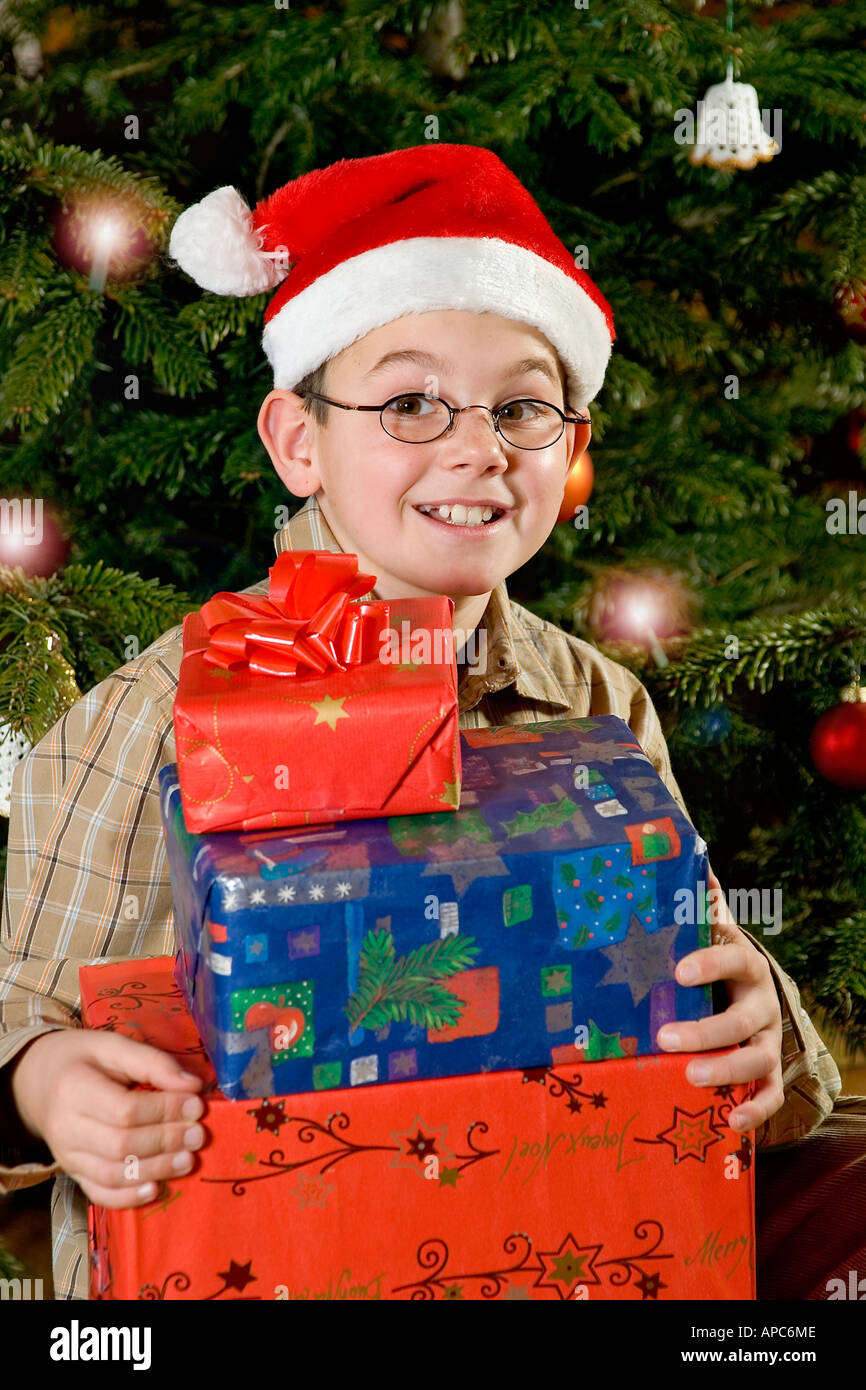 Un garçon de dix ans avec des cadeaux de Noël la veille de Noël Banque D'Images