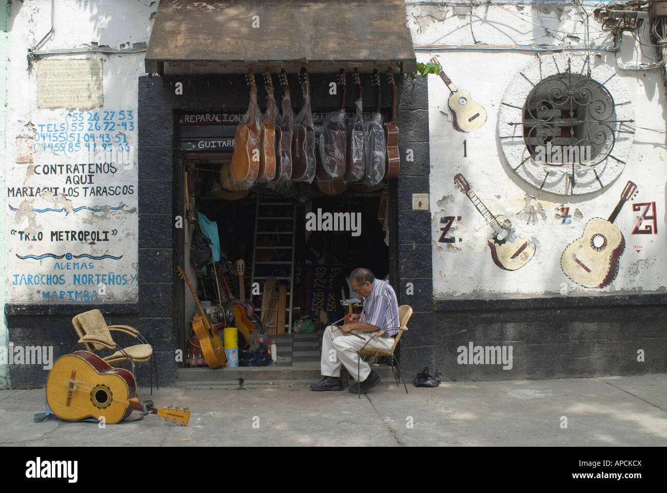 Un réparateur de guitare travaille en face de son magasin dans le centre historique de la ville de Mexico Banque D'Images