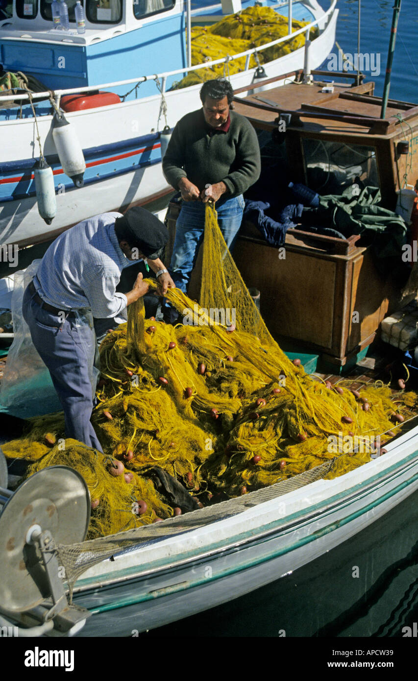 Deux hommes raccommodage des filets de pêche en Europe Crète Héraklion port Banque D'Images