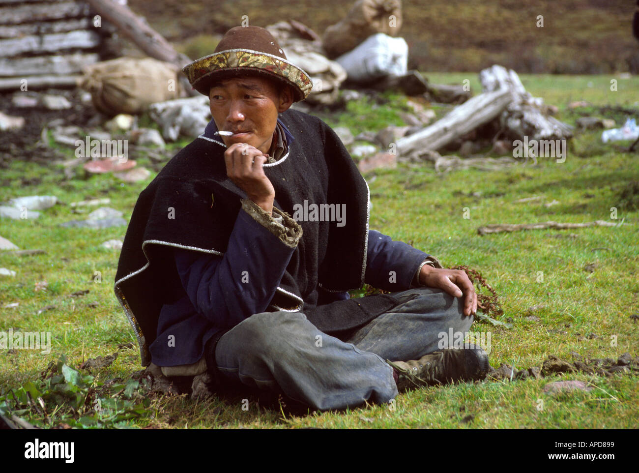 Xizang Kongpo, dans la région tibétaine traditionnelle Kongpo robe costume mao et estimé et brocade hat fumer une cigarette,Chine, Tibet Banque D'Images