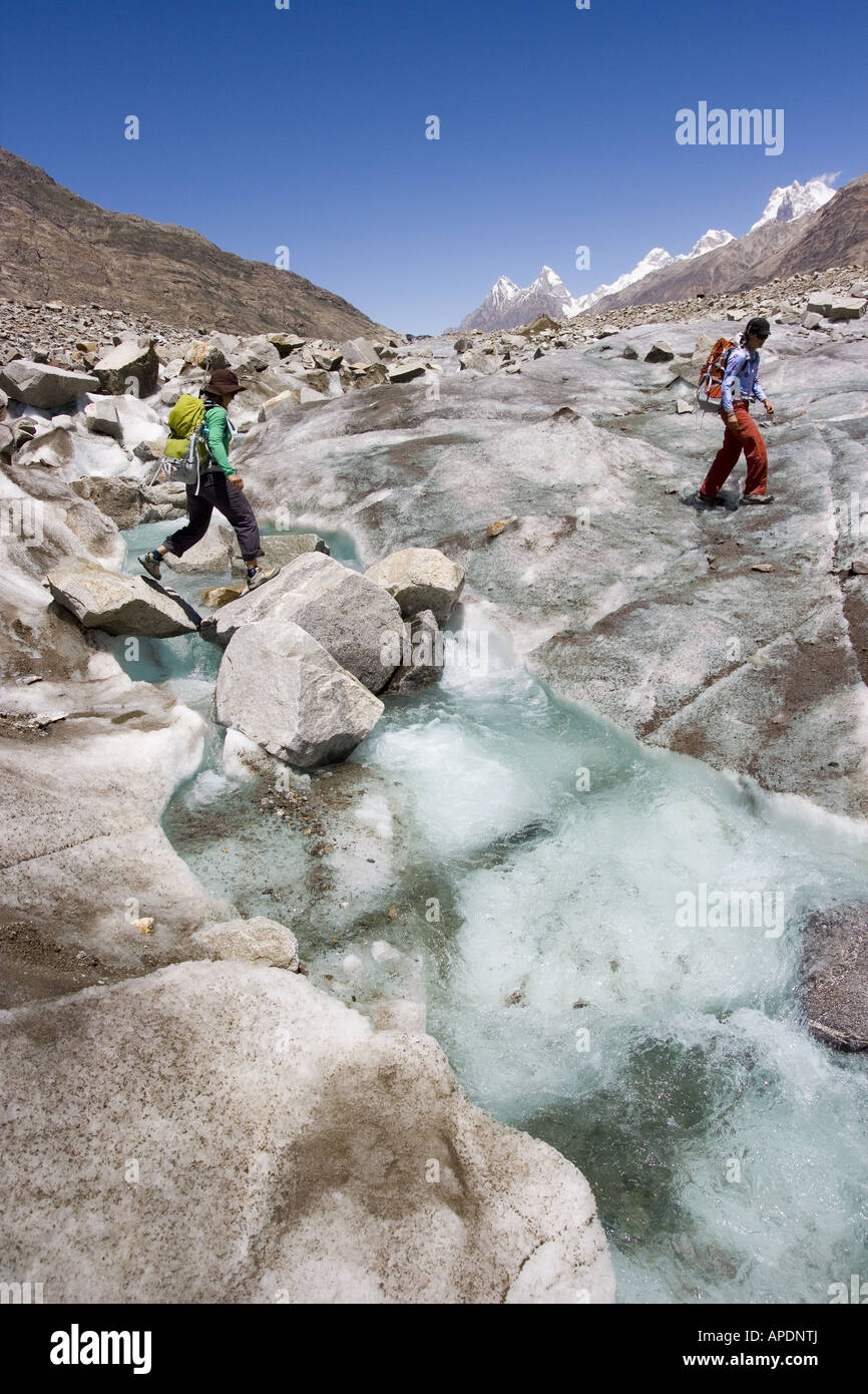 Deux femmes traversant un ruisseau sur le Biafo glacier dans l'Himalaya Karakoram au Pakistan Banque D'Images