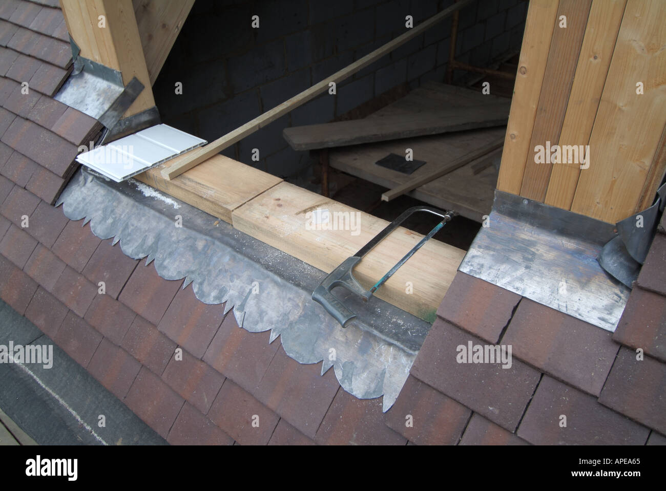 Gros détails de plomb clignotant vêtu autour de la fenêtre de dormer et des matériaux de construction de tuiles de toit dans la nouvelle maison indépendante sous la construction Angleterre Royaume-Uni Banque D'Images