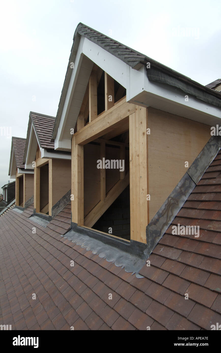 Construction de maison indépendante site matériaux de toit par Marley béton tuiles simples & contreplaqués revêtus de dormer fenêtres avec plomb clignotant Angleterre Royaume-Uni Banque D'Images