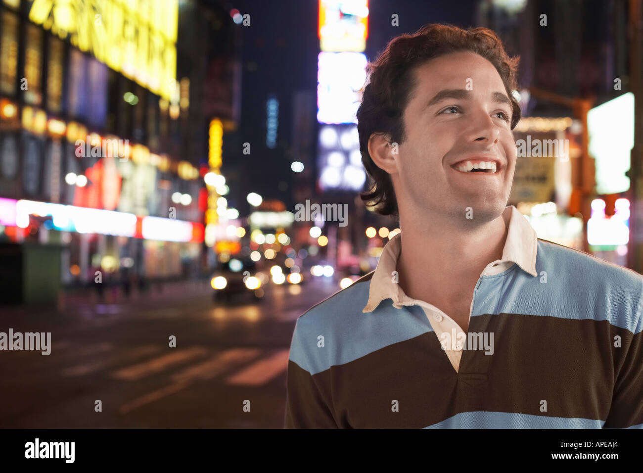 Young man standing in Times Square New York la nuit Banque D'Images