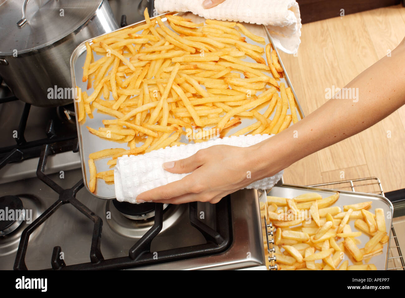 Femme DANS LA CUISINE CUISINE PLAQUETTES / Frites Banque D'Images