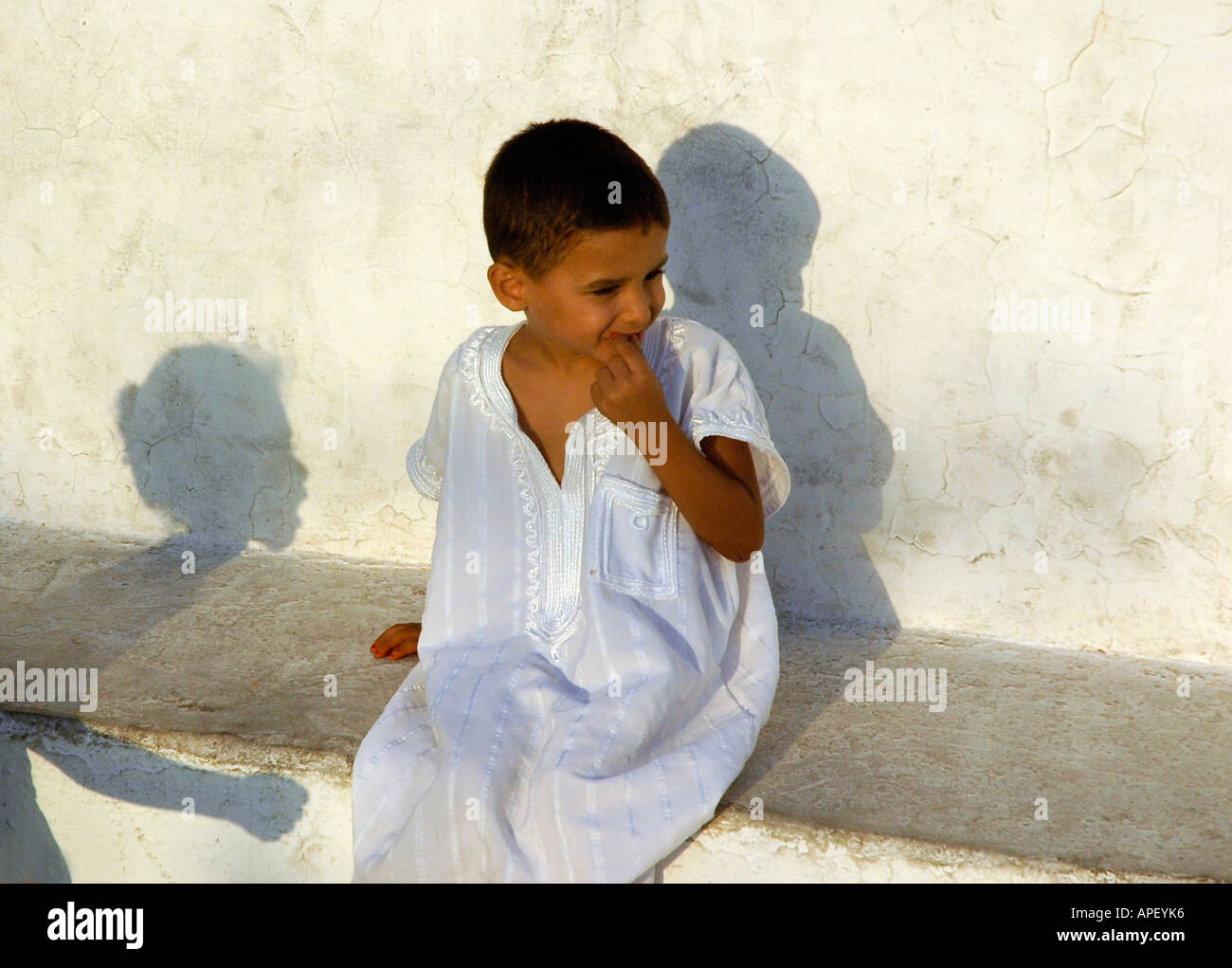 Un enfant en blanc robe traditionnelle dans le village de Sidi Bou Saïd, au nord de Tunis, Tunisie. Banque D'Images