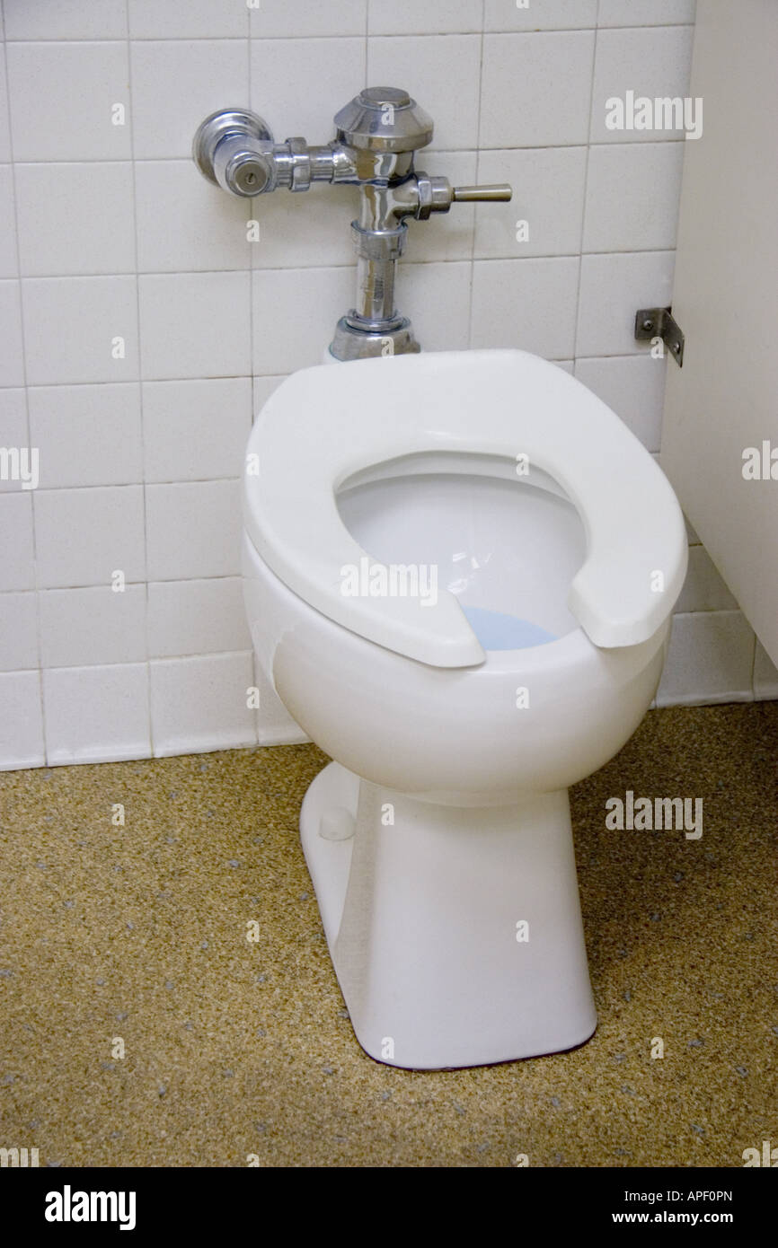 Cabine de toilettes en porcelaine blanche avec de l'eau bleue à l'intérieur. Banque D'Images