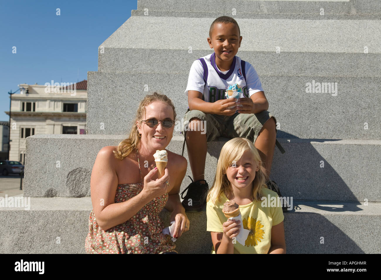 WISCONSIN Racine femme siéger le monument étapes avec deux enfants eating ice cream cones Banque D'Images