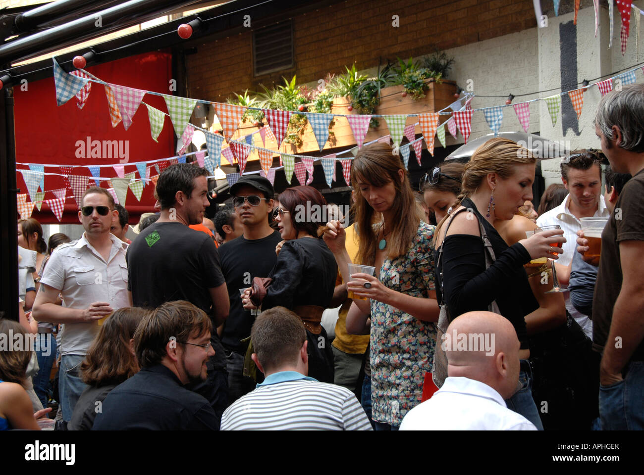 Les jeunes de manger à l'extérieur de l'alcool hors pub Brick Lane East End de Londres. Banque D'Images