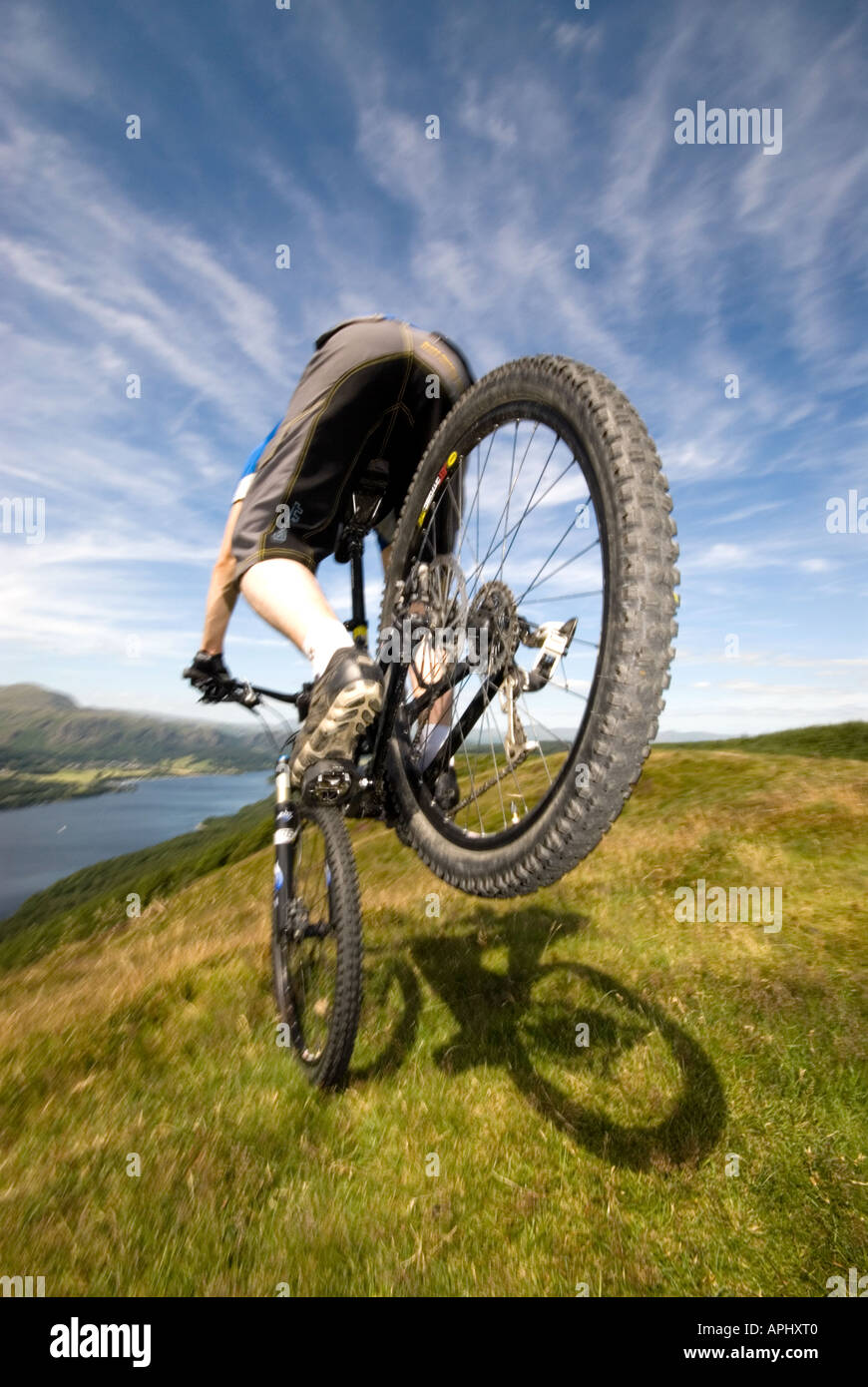 Vélo de montagne de l'exécution d'un stoppie à Coniston Water Lake District Angleterre Banque D'Images