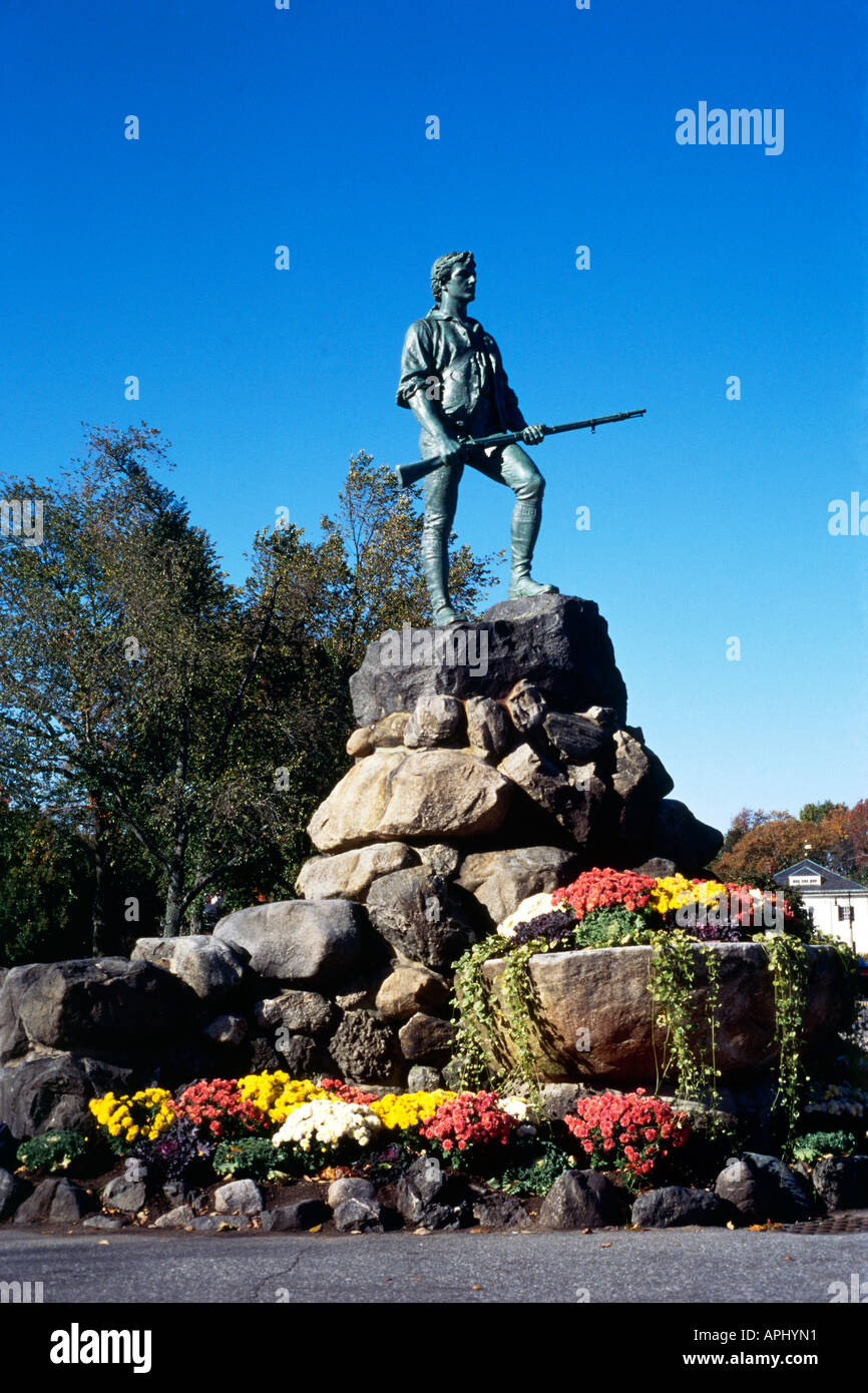 La statue de Le Capitaine Parker sur un ciel bleu clair et au sommet d'une grande rocaille avec une masse de fleurs colorées et de fin de la base de décoration lierre à Lexington Green Village Banque D'Images