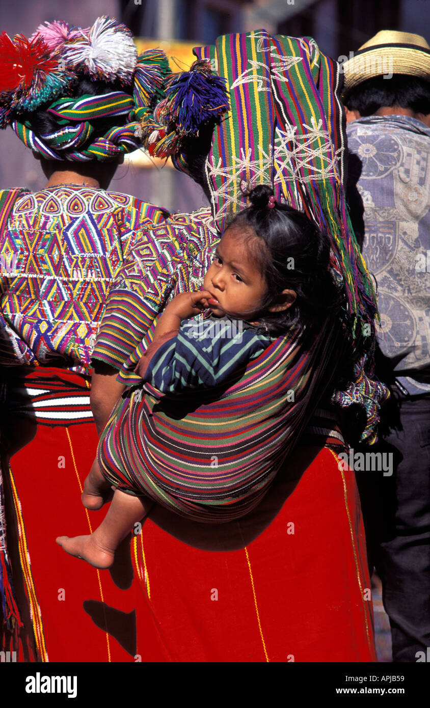 Jeune fille Maya en cours sur son dos dans un porte-bébé châle triangle Ixil Nebaj El Quiché au Guatemala Banque D'Images