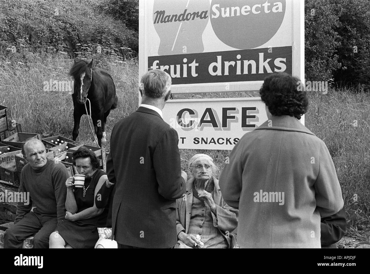 Sortie en famille des années 1970 buvant une tasse de thé sous l'extérieur sous un panneau de café. Matlock Derbyshire 1970 Royaume-Uni. HOMER SYKES Banque D'Images