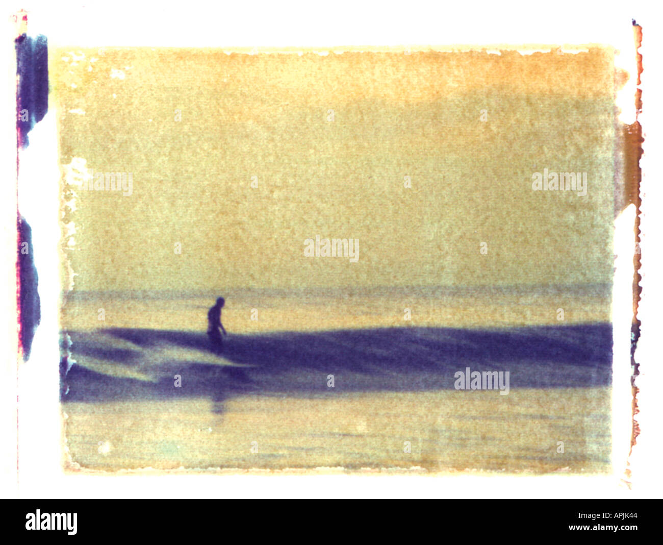 Type 59 Polaroid image transfert de l'image floue d'un surfeur de longboard au coucher du soleil prise à partir d'une diapositive de 35mm Banque D'Images