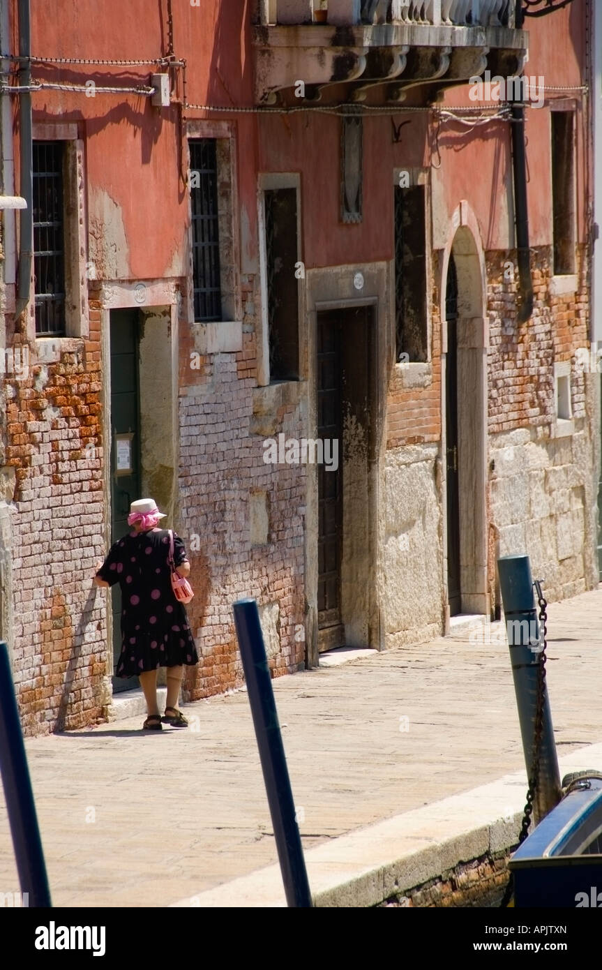Image de vieille dame italienne marchant à côté d'un canal à Venise, Italie. Peut être utilisé pour illustrer la vieillesse, l'isolement ou similaire. Banque D'Images