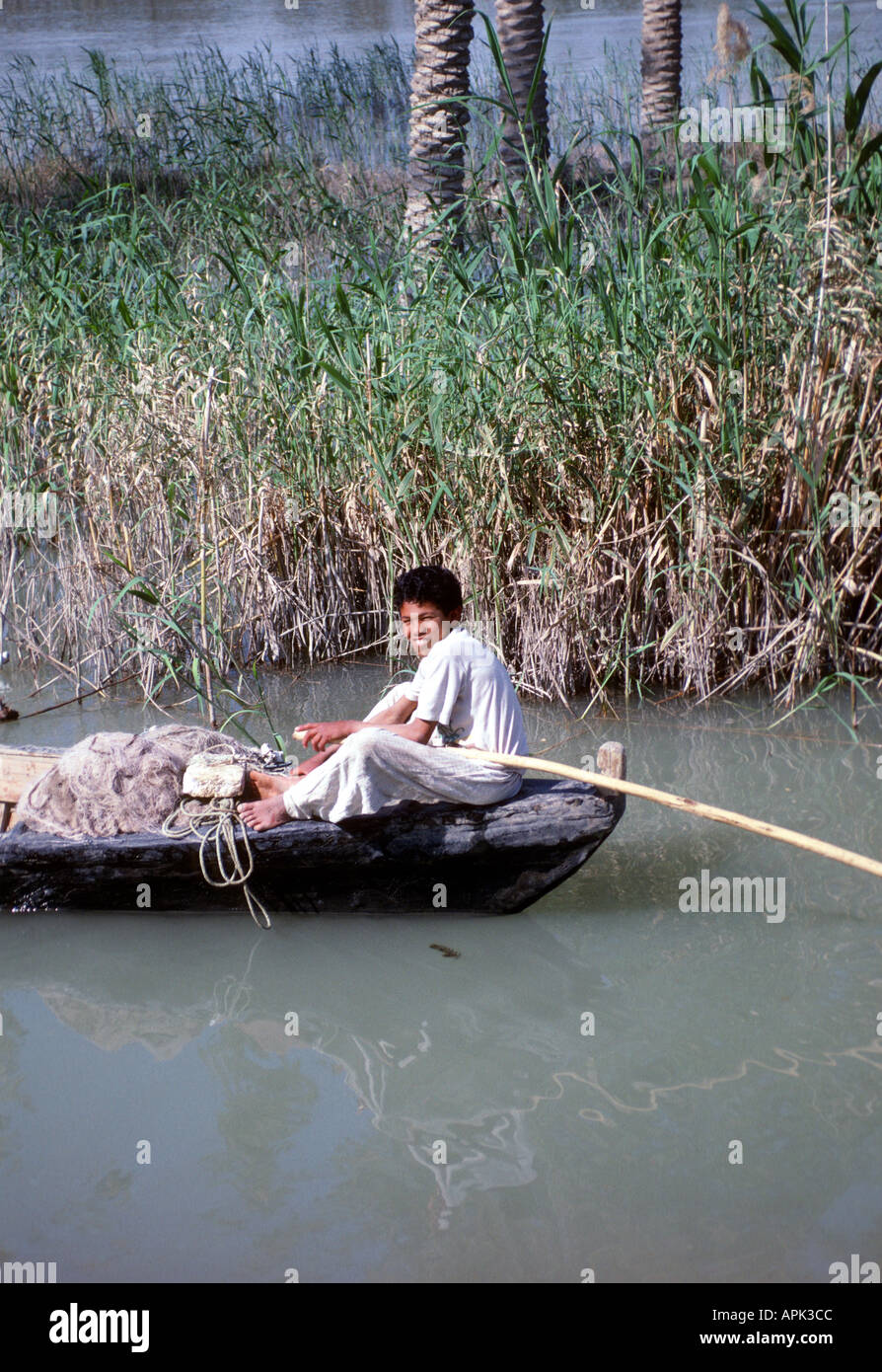 Nassiriyah Irak jeune garçon de pêche bateau en bois sur l'Euphrate près de Nassiriyah, bombardé en première guerre du Golfe Banque D'Images