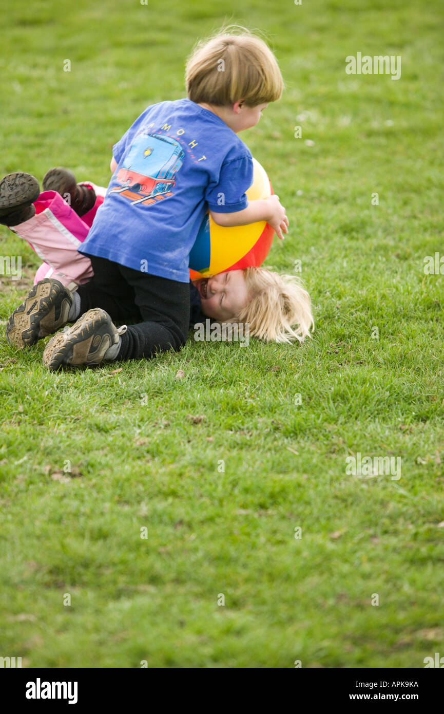 Kids Wrestling sur l'herbe Banque D'Images