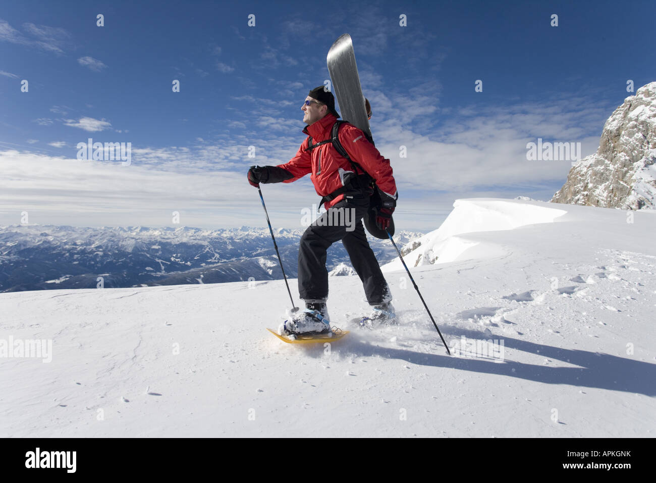 Man with snowboard sur le dos à la raquette dans les montagnes, Autriche Banque D'Images