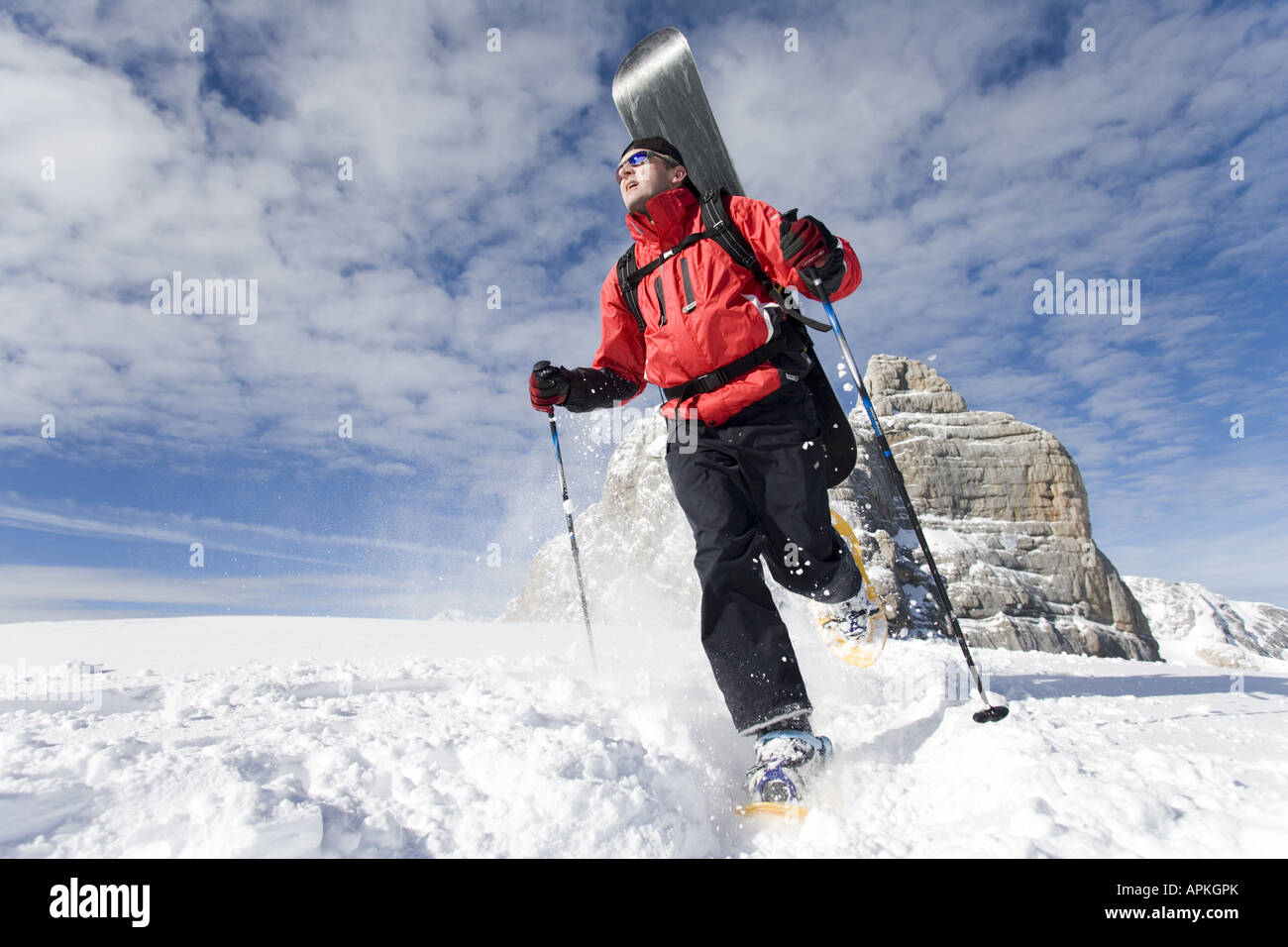 Man with snowboard sur le dos à la raquette dans les montagnes, Autriche Banque D'Images