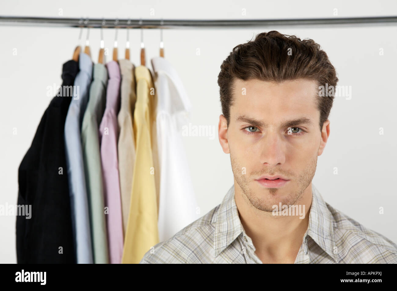 Jeune homme avec rack de vêtements Banque D'Images