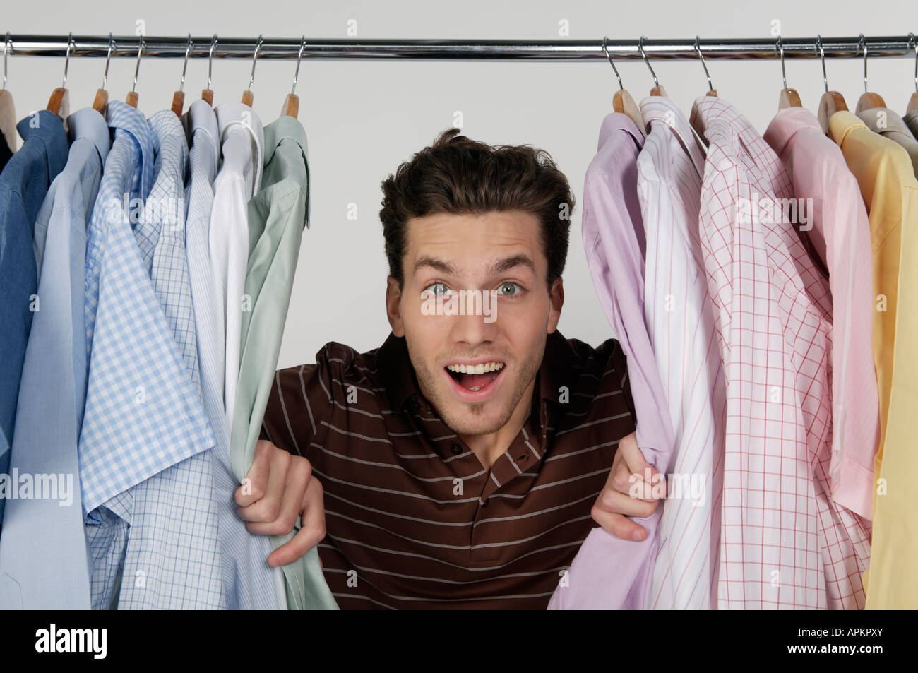 Jeune homme avec rack de vêtements Banque D'Images