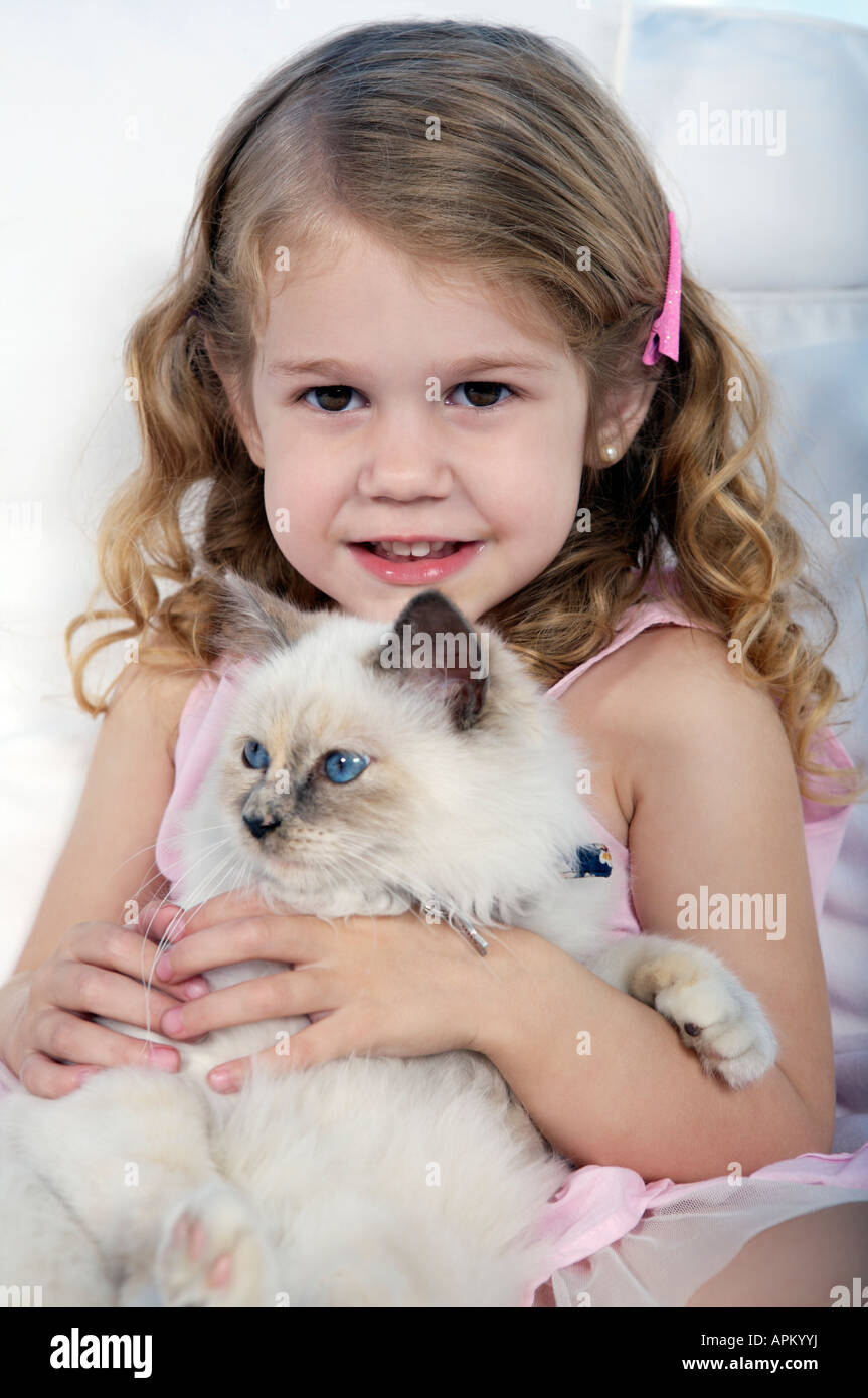 Petite fille jouant avec siamesse chaton Banque D'Images