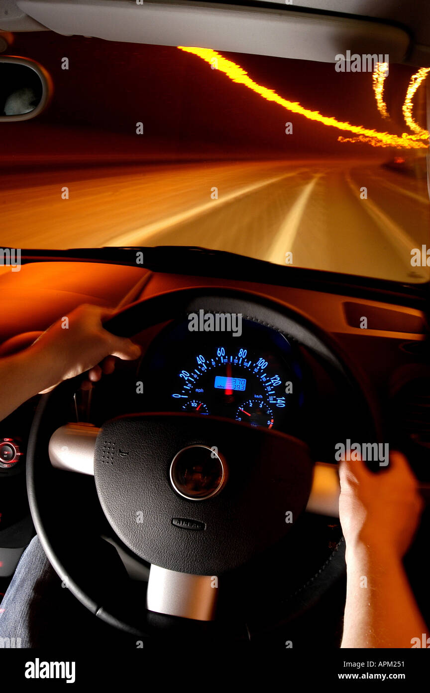 Les mains sur un volant d'autoroute la scène de nuit, portrait 2005 vw golf convertable Banque D'Images