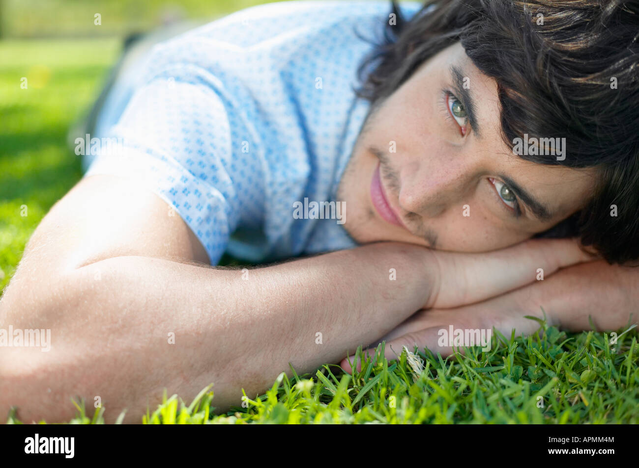 Young man lying on grass (portrait) Banque D'Images