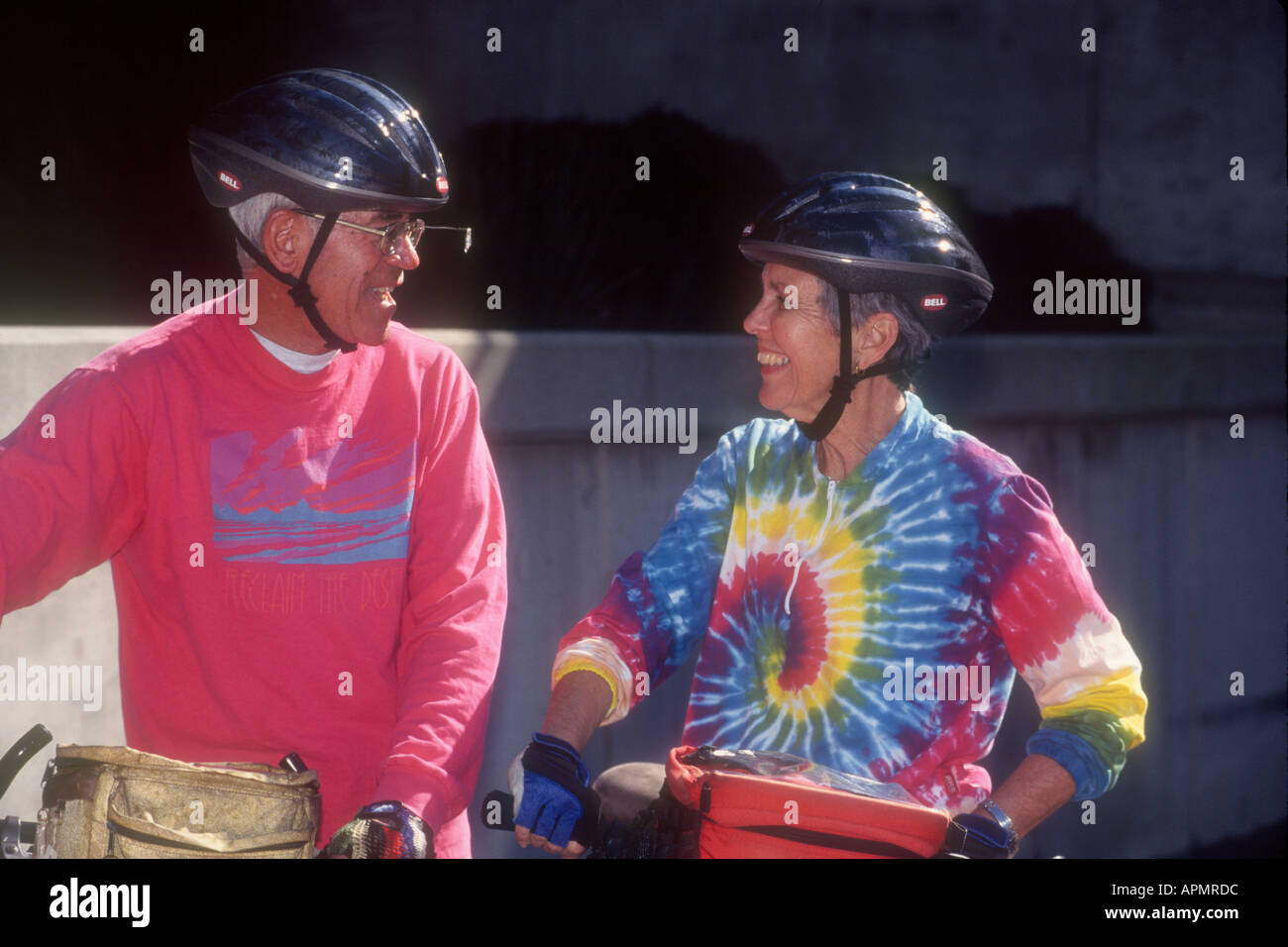 Senior couple in maillots colorés et casque de vélo, le chat avant de reprendre le vélo.Redondo Beach, CA. USA Banque D'Images