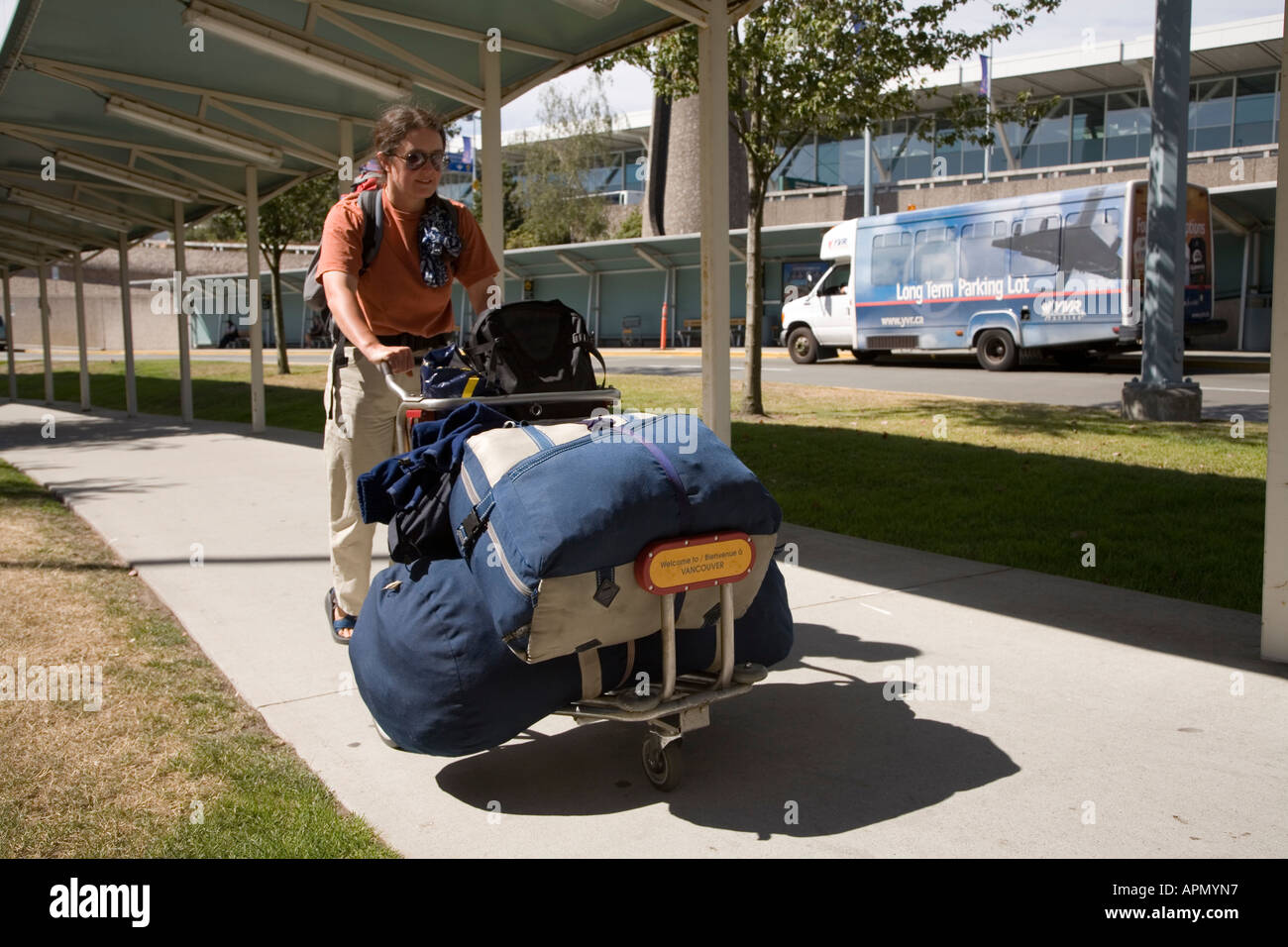 Woman poussant chariot aéroport Vancouver Canada sacs chargés de Banque D'Images