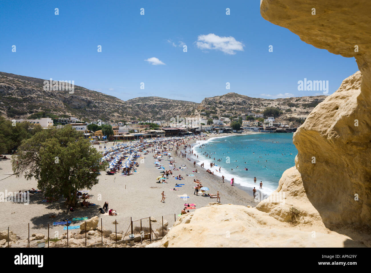 Vue sur la plage et village de la falaise et grottes, Matala, Côte Sud, Province d'Héraklion, Crète, Grèce Banque D'Images