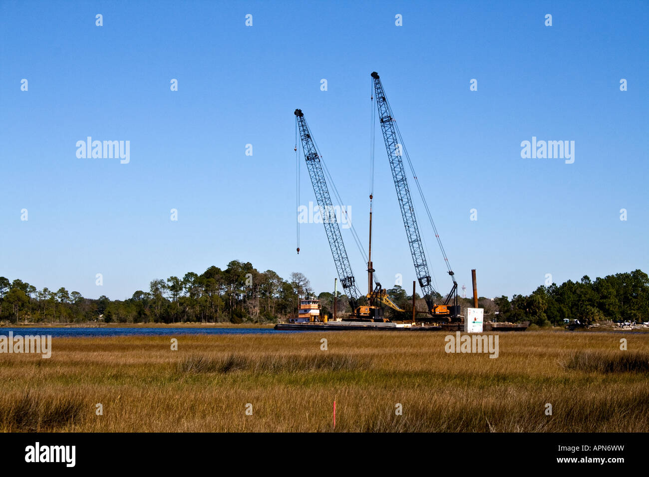 Deux grues industrielles flottant sur le marais Banque D'Images