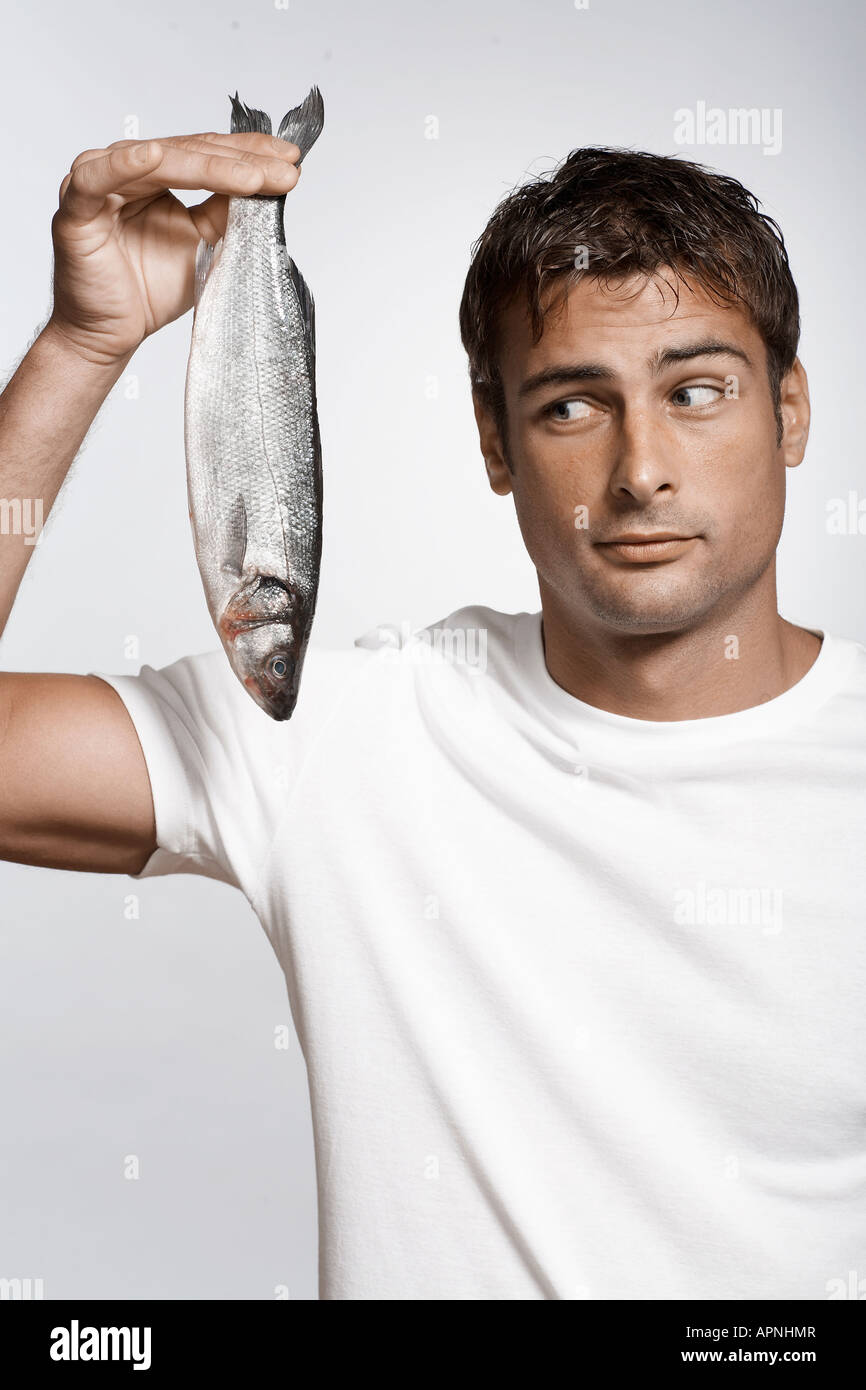 Mid adult man holding striped sea bass Banque D'Images