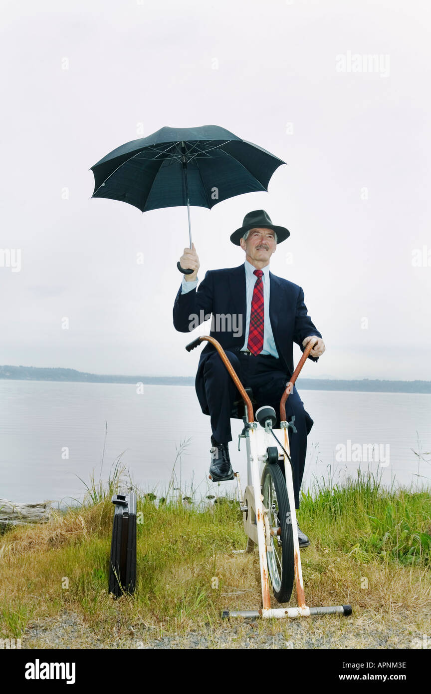 Businessman riding vélo stationnaire près du lac Banque D'Images