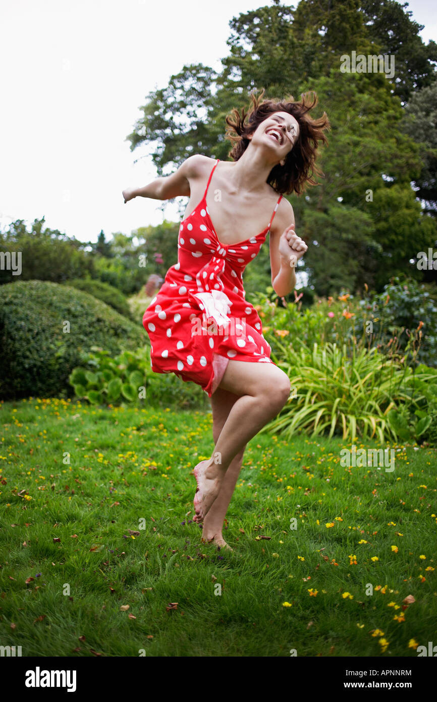 Jeune femme sautant sur l'herbe Banque D'Images