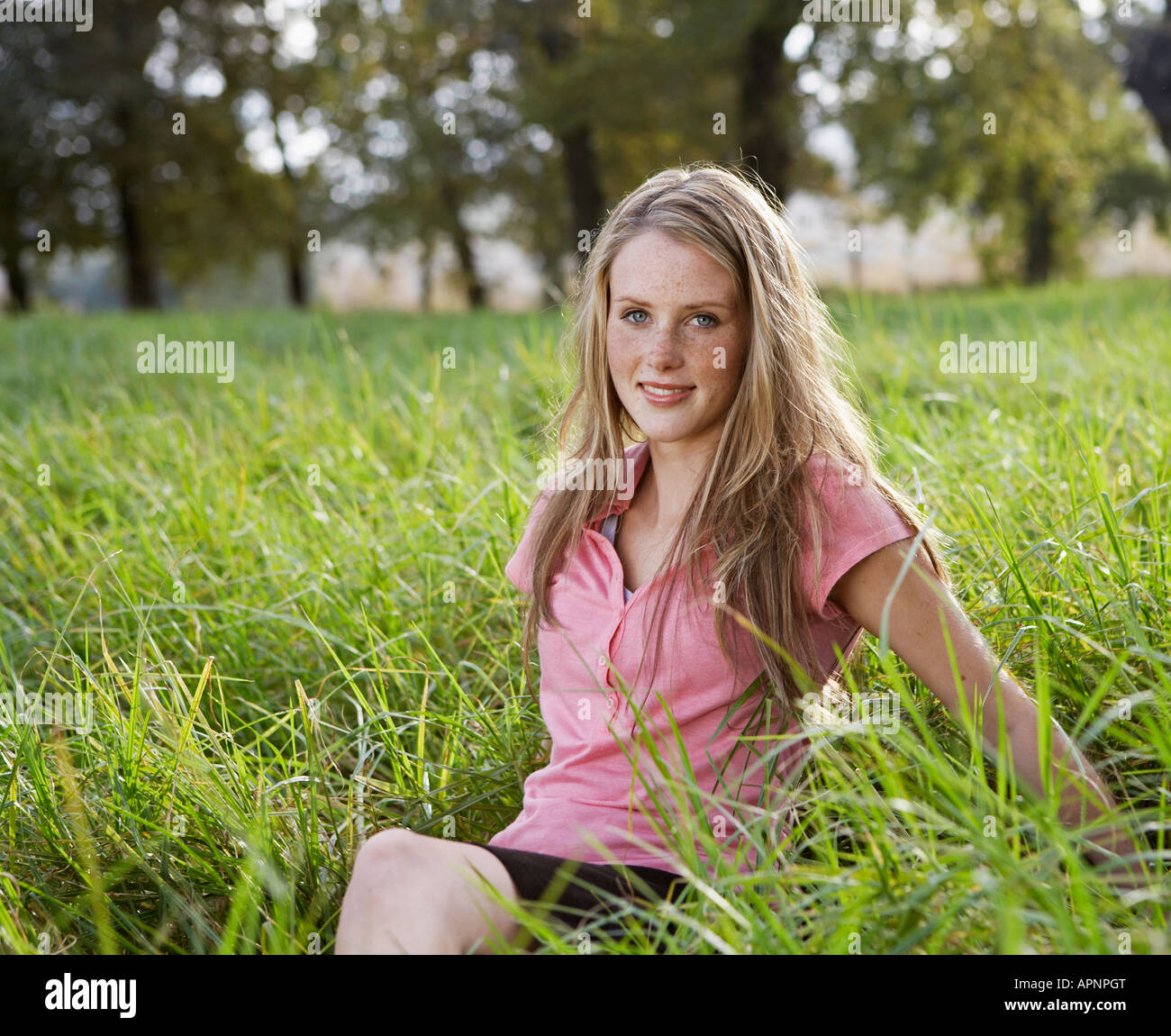 Teenage Girl Sitting in Field Banque D'Images