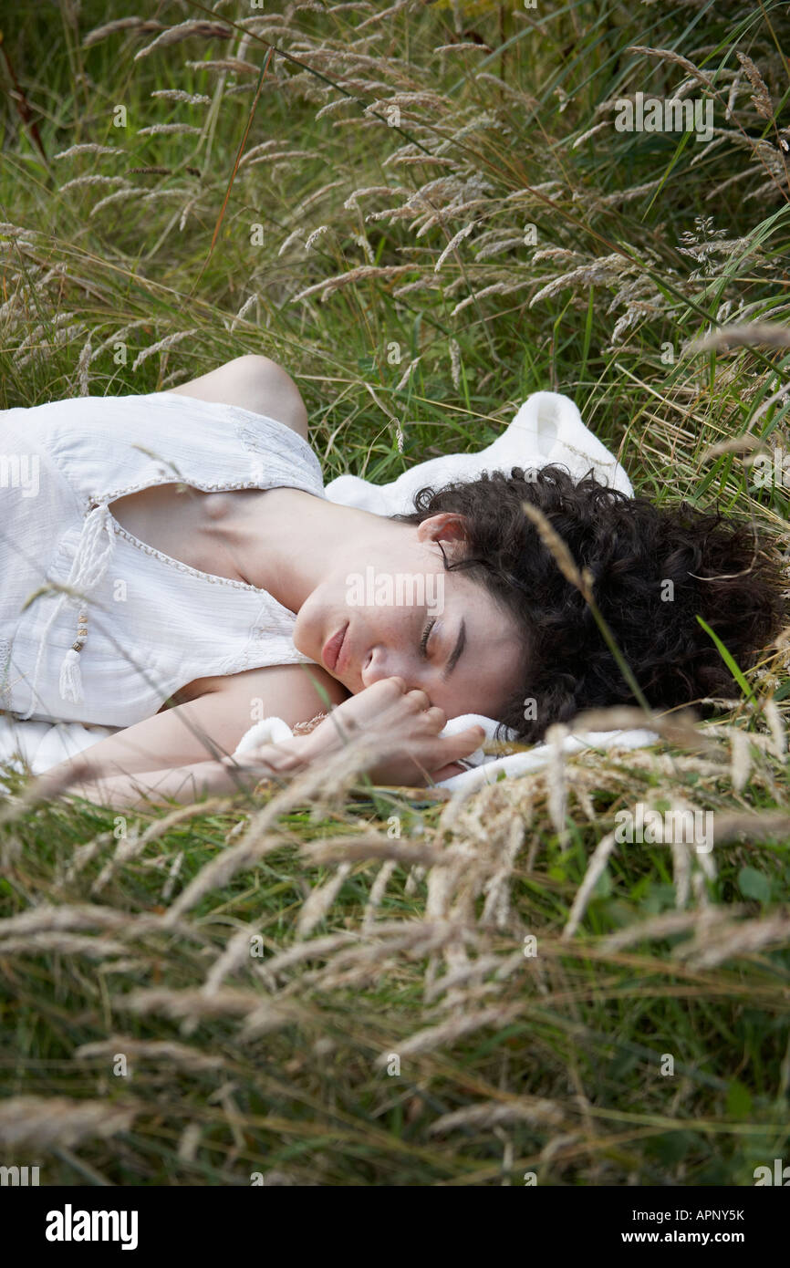 Jeune femme allongée sur l'herbe haute Banque D'Images