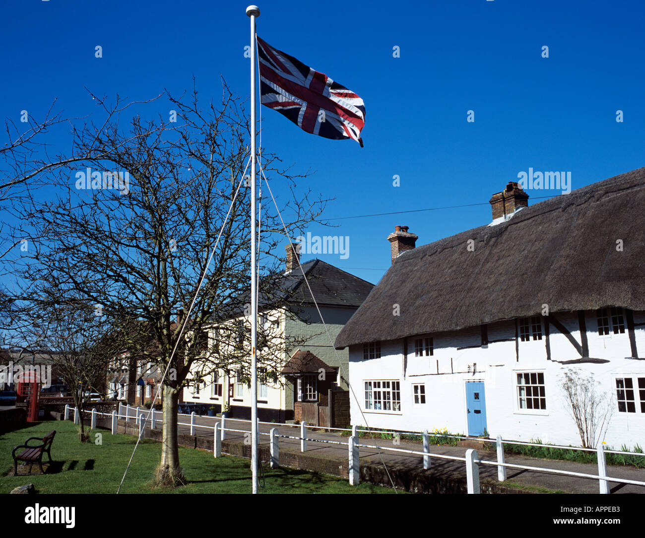 Union Jack flag et chaumières par Triangle rondelles sur les rives de village green River East Meon Meon Hampshire England UK Banque D'Images