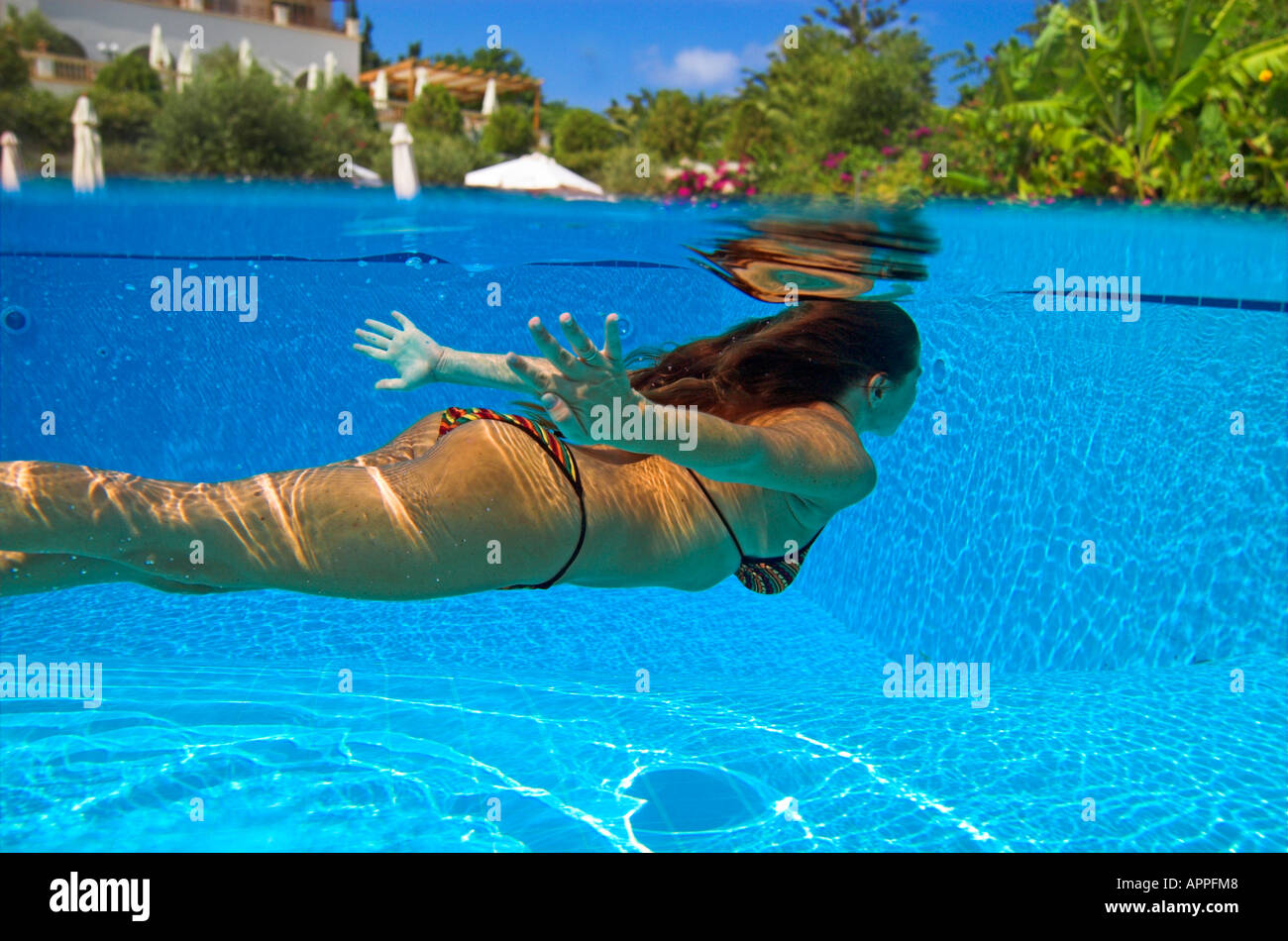 Woman in bikini sous-marine Plongée en piscine hôtel au-dessus de l'eau Banque D'Images