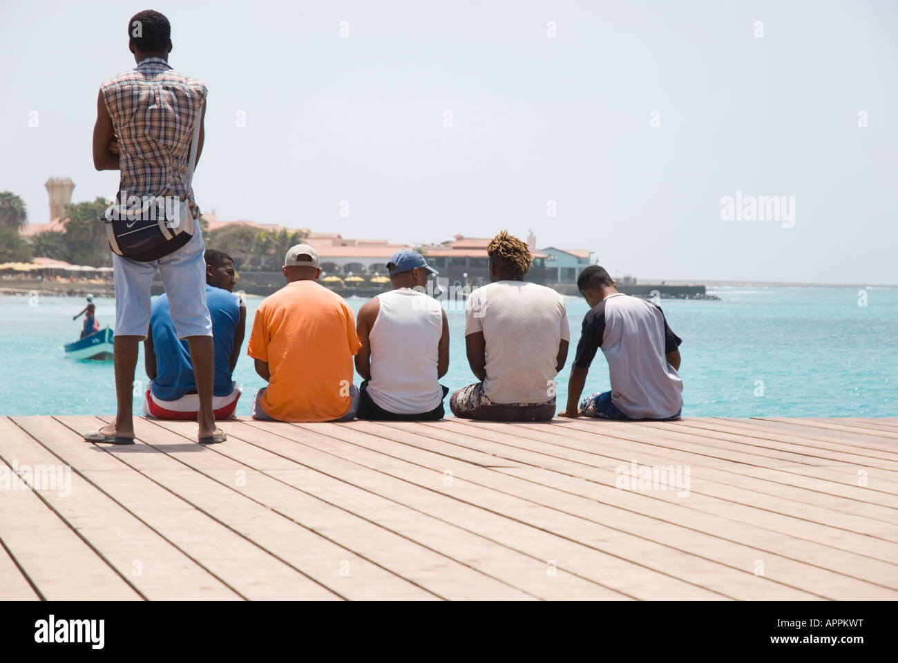 Un paysage couleur de six hommes de l'endroit à la recherche sur l'eau dans la ville de Santa Maria,Sal,Iles du Cap Vert. Banque D'Images