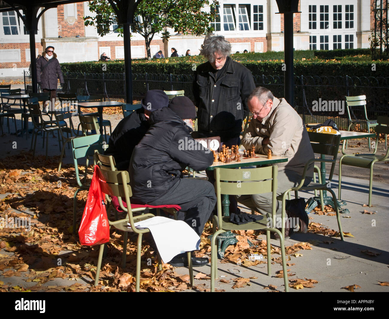Quatre hommes jouant aux échecs dans la fin de l'automne, soleil dans le Jardin du Luxembourg, parc de la ville de Paris France Europe Banque D'Images