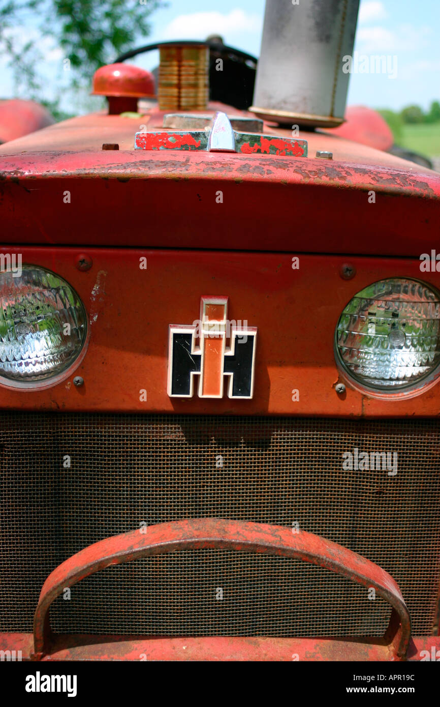 Équipement agricole tracteur bineuse la récolte de l'herbe verte rural blue sky clouds pneu rouge antique antique tondeuse John Deer charrue Banque D'Images