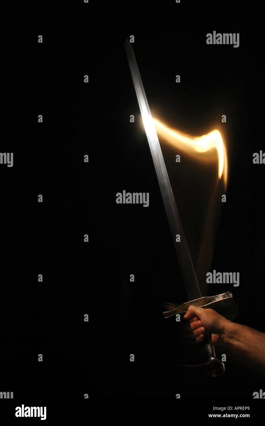 Épée à la main à l'obscurité. Banque D'Images