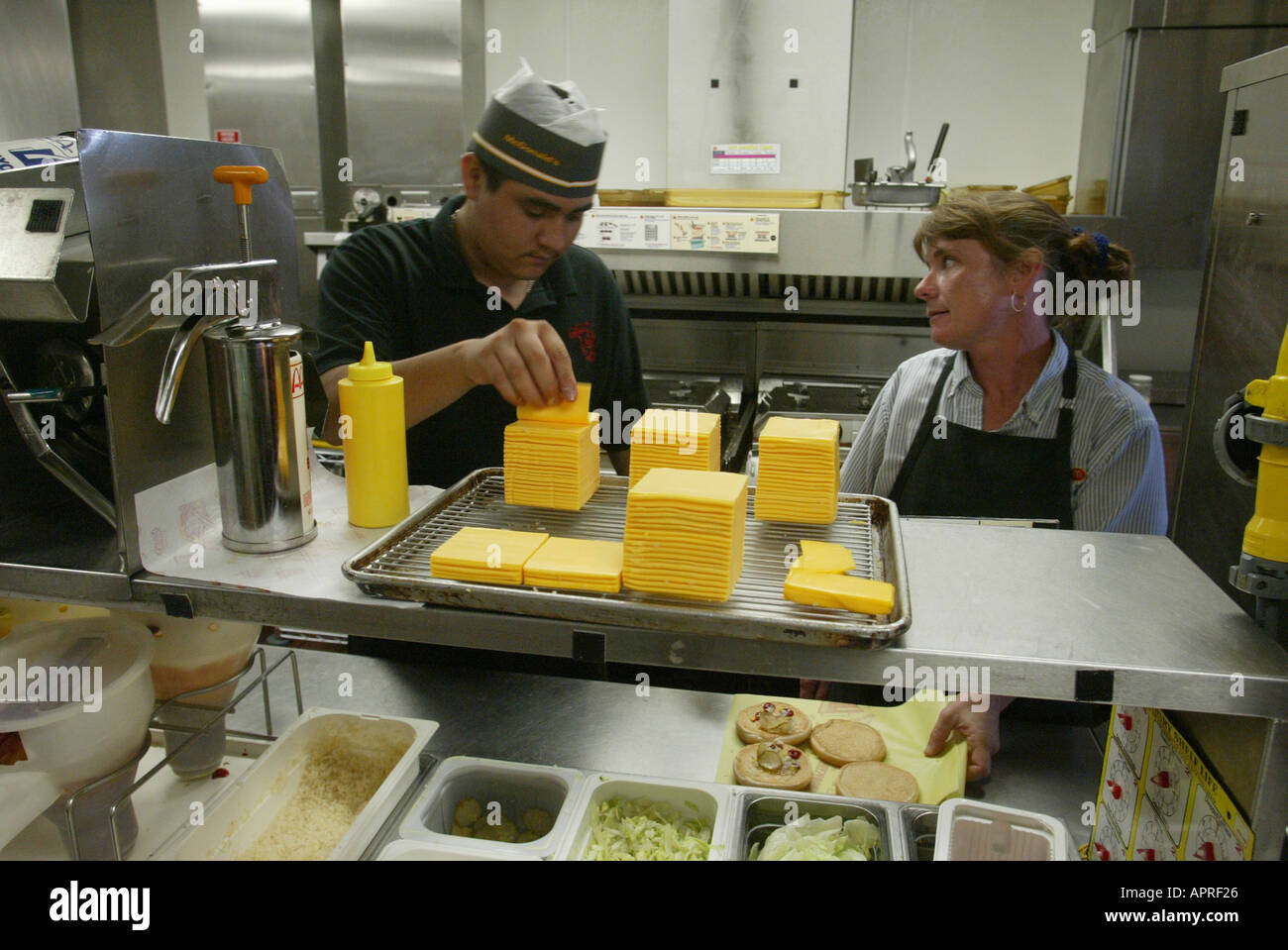 Deux employés travaillant dans une cuisine à un restaurant McDonalds  travailleurs à faible revenu restauration rapide Photo Stock - Alamy