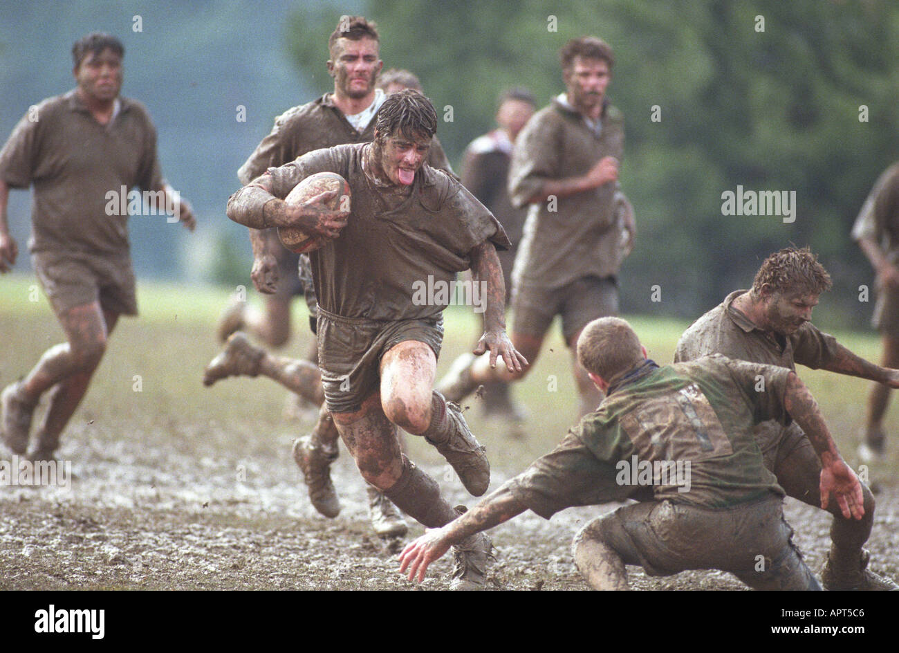 Joueur de rugby boueux s'exécutant dans la boue avec le ballon. sportif gagnant gagnant des mâles de la concurrence Banque D'Images