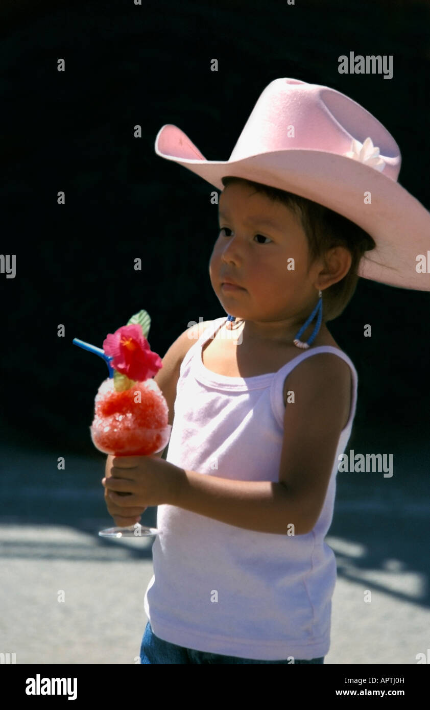 Little Indian girl with pink hat mangeant une glace rose Banque D'Images