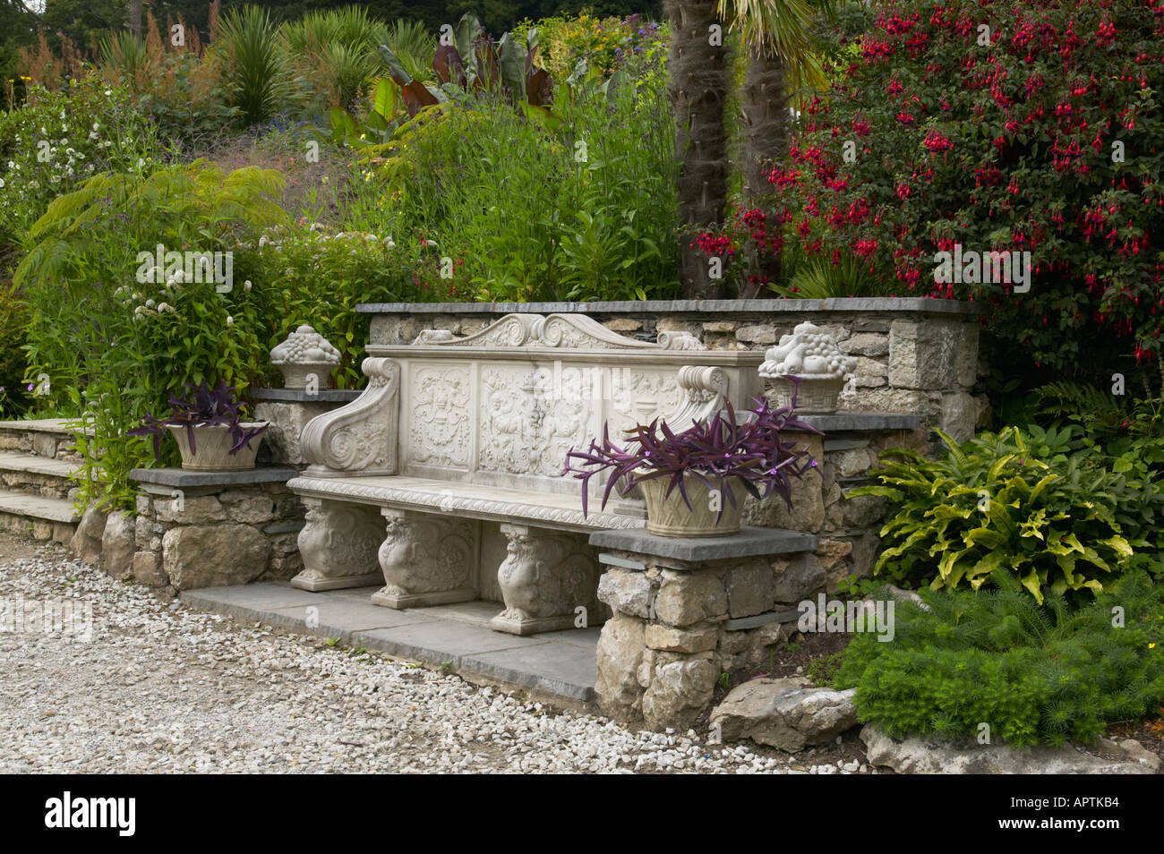 Yewbarrow chambre jardin avec banc calcaire plantation exotique avec des piliers de croissance aux côtés de l'hosta Fuschia Banque D'Images